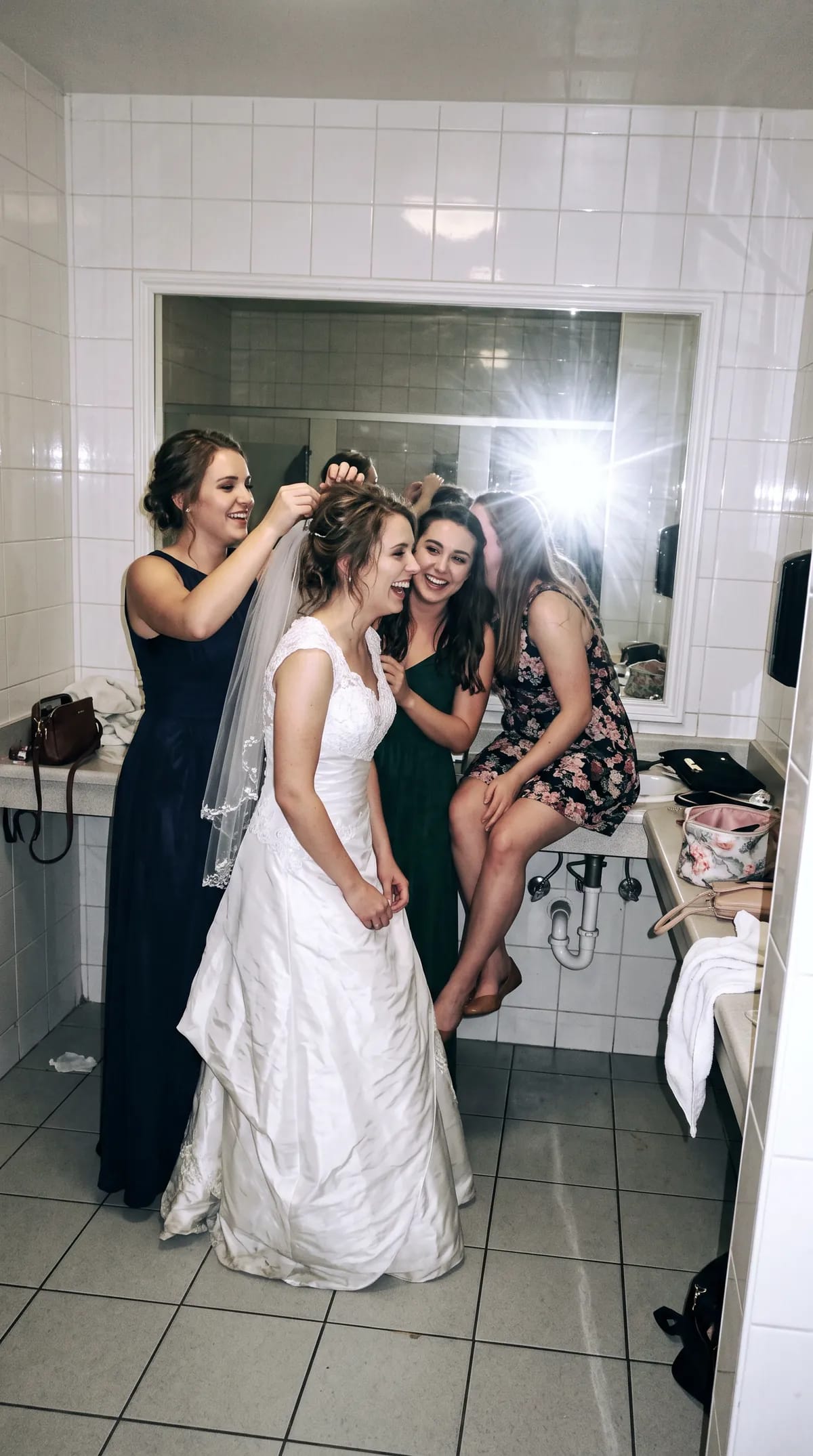 Mariée entourée de ses amies devant un miroir